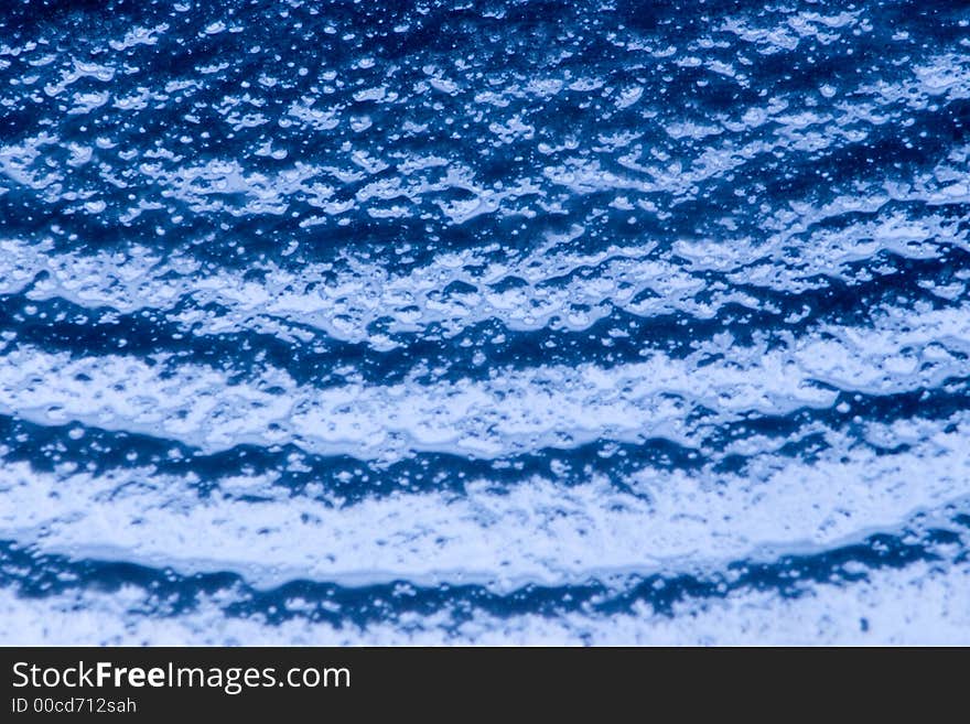 Detail of a bubbled glass with blu natural gradient. Detail of a bubbled glass with blu natural gradient