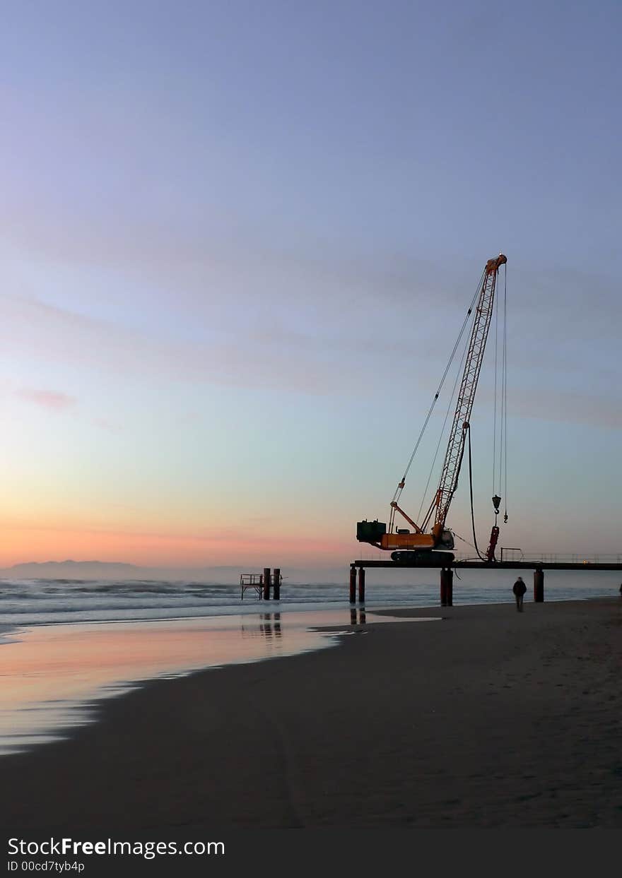 A building machine is left in the coast near the sea. A building machine is left in the coast near the sea