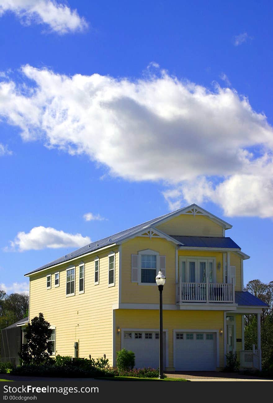 2-story yellow american dream home against perfect blue sky and garage. 2-story yellow american dream home against perfect blue sky and garage