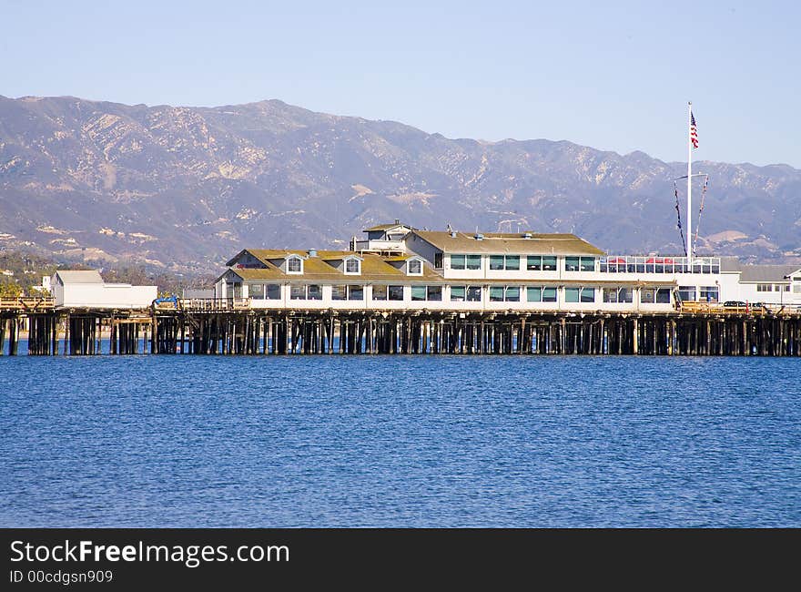 Several business buildings are situated on an old pier extending into the ocean. Several business buildings are situated on an old pier extending into the ocean.