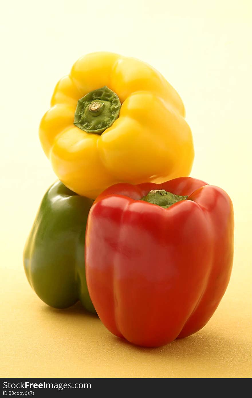 Red, green and yellow pepper on a yellow background. Red, green and yellow pepper on a yellow background