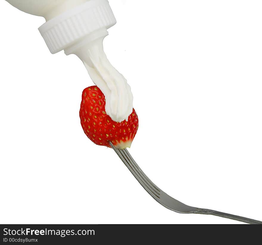 Applying whip cream on a strawberry in fork-isolated over white background. Applying whip cream on a strawberry in fork-isolated over white background.