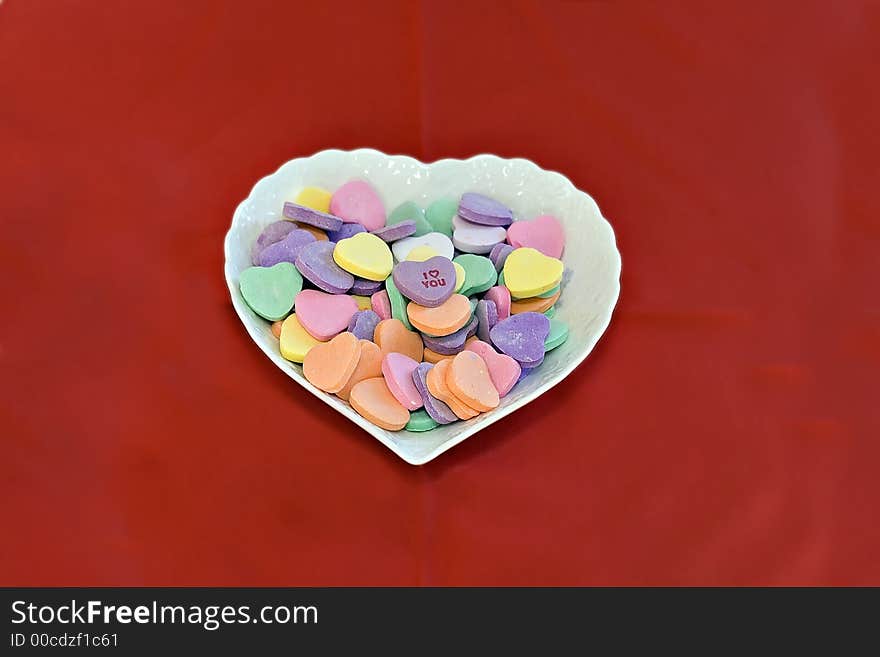 Heart shaped dish of conversation hearts.  I love you on top. Heart shaped dish of conversation hearts.  I love you on top.