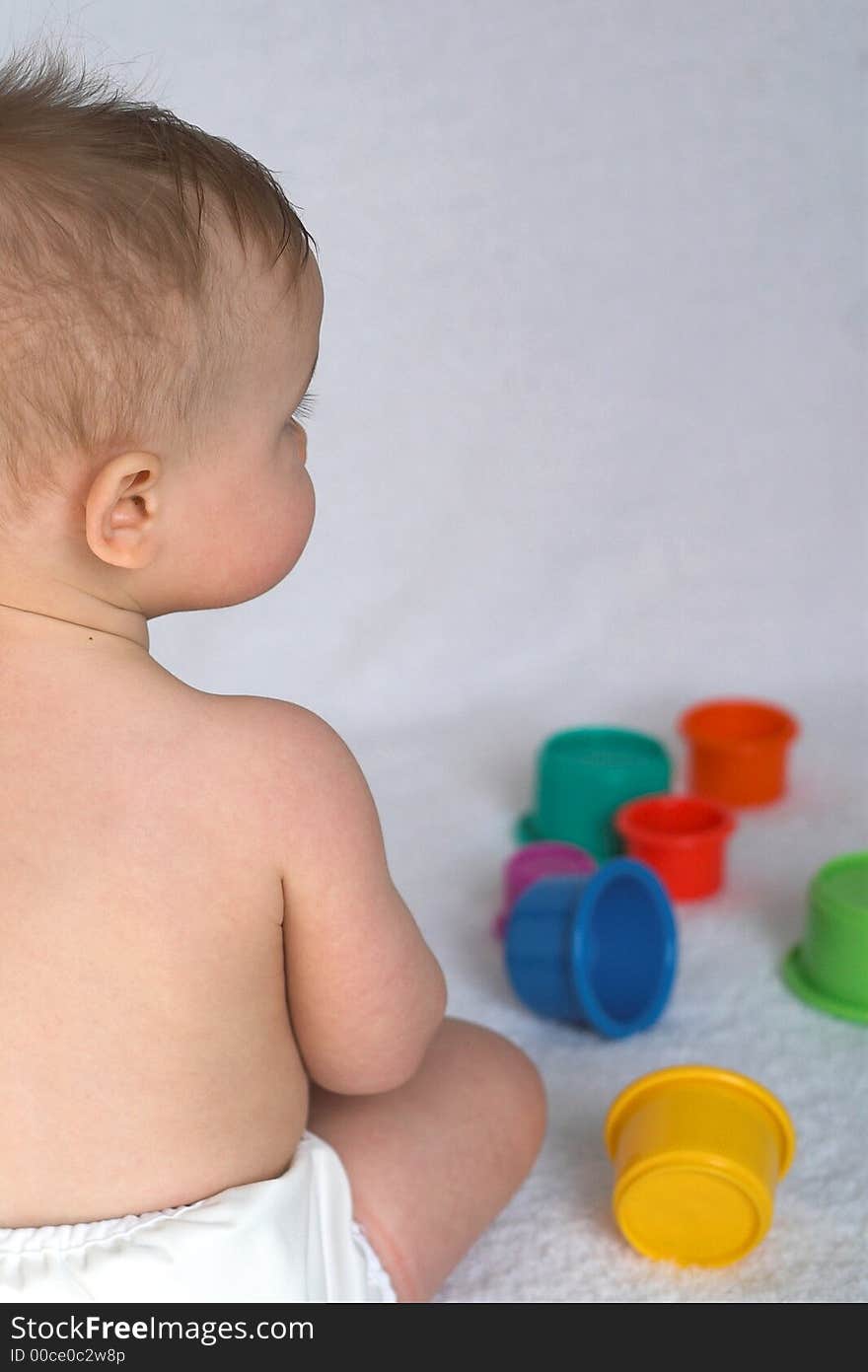 Image of adorable baby playing with stacking cups. Image of adorable baby playing with stacking cups