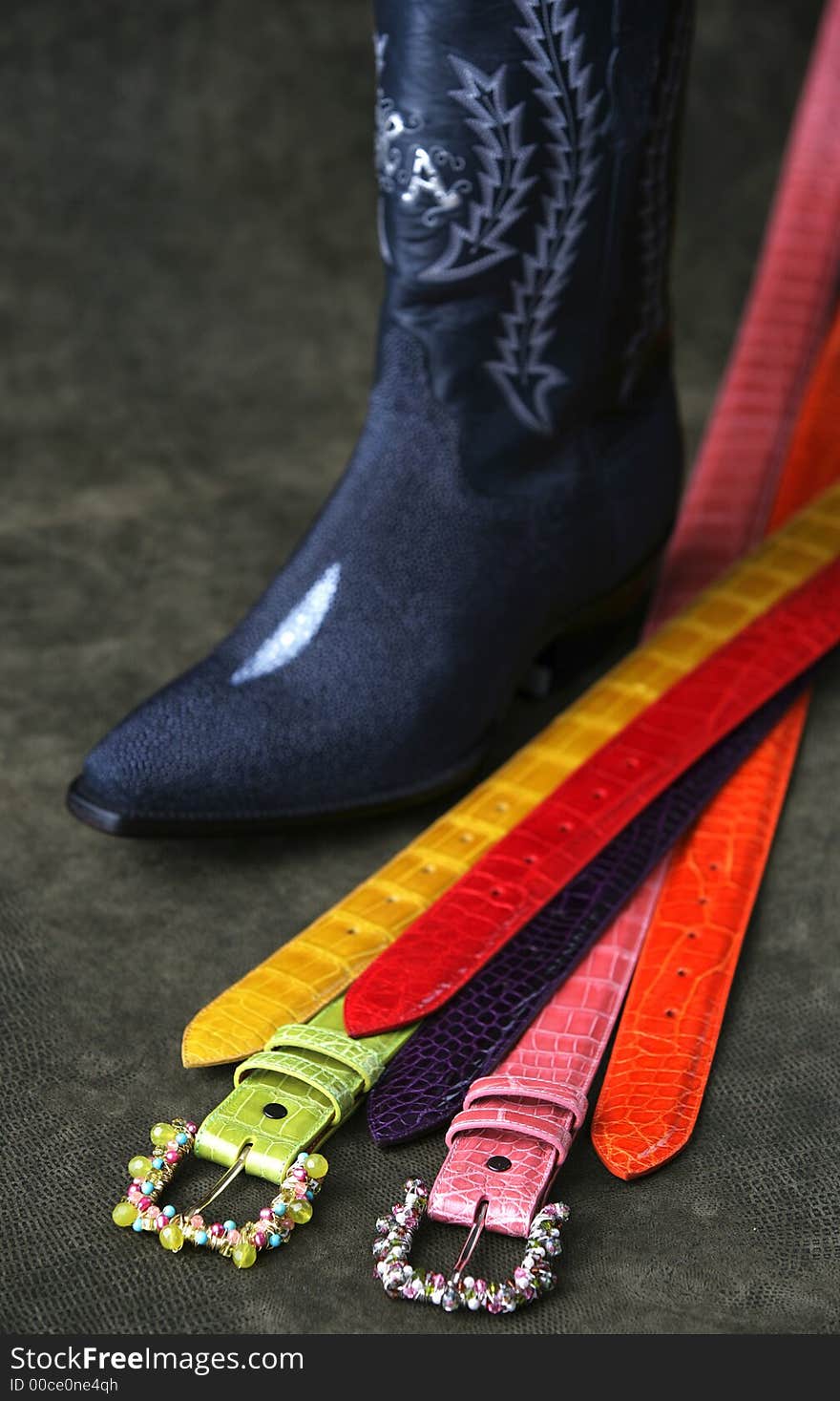 Western colorful belts and a cowboy boot. Western colorful belts and a cowboy boot