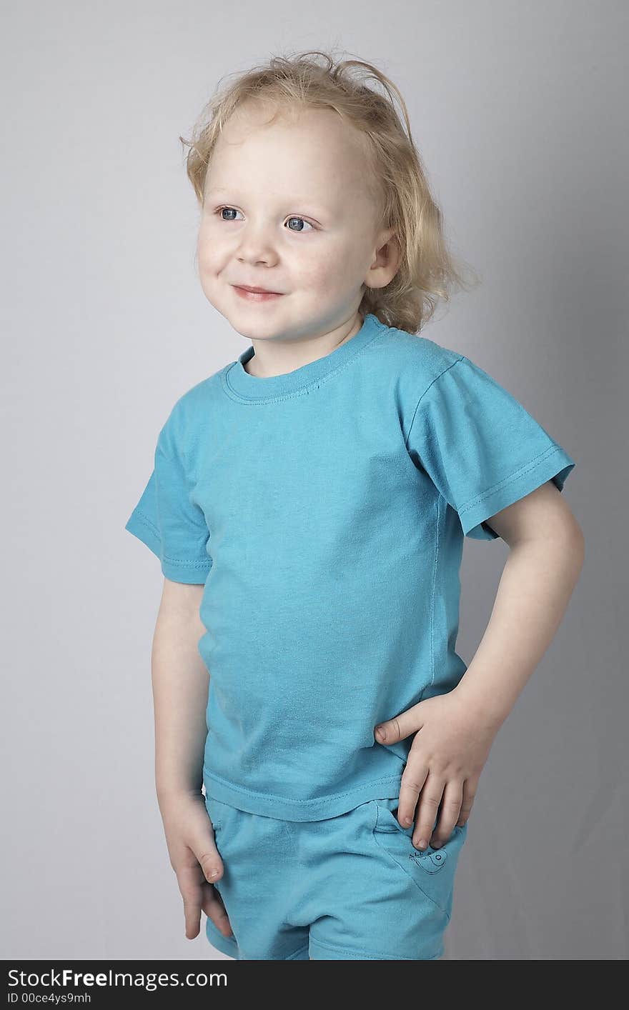 Smiling blond little child in blue clothes. Smiling blond little child in blue clothes