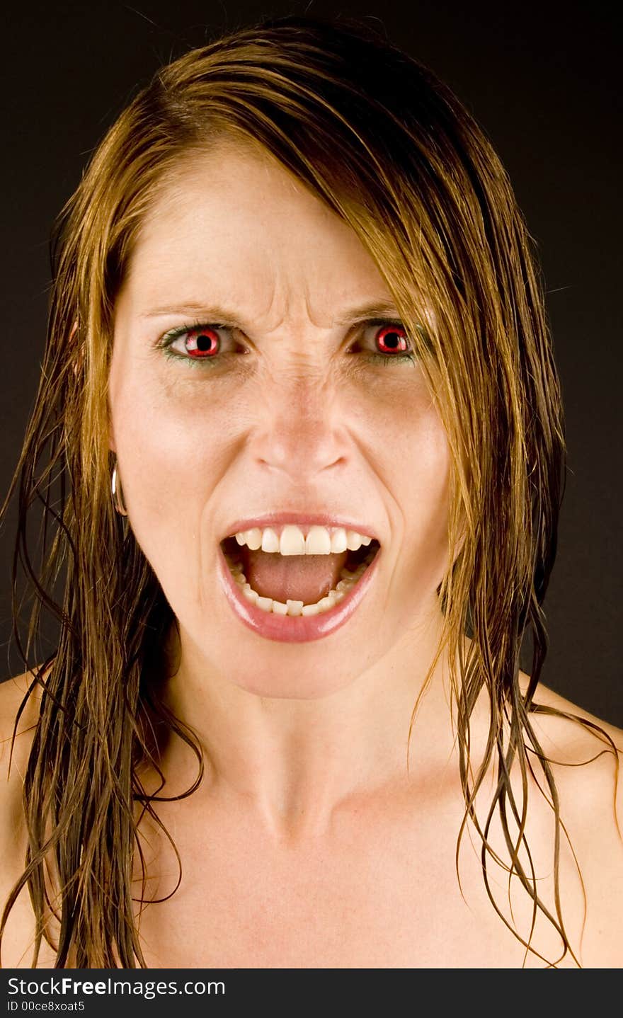 An Angry young woman with wet hair against a plain background. An Angry young woman with wet hair against a plain background.