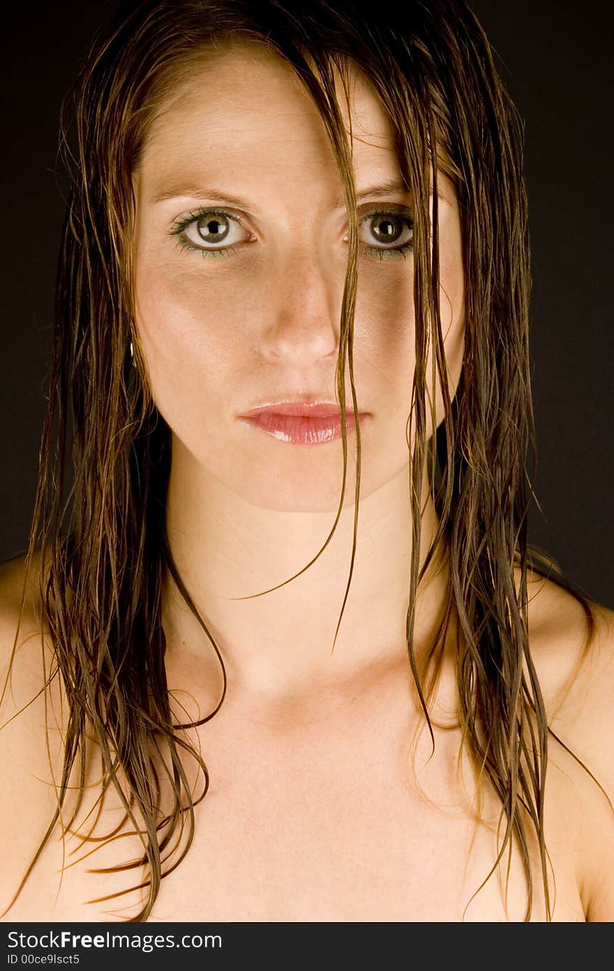 A young woman with wet hair against a plain background.