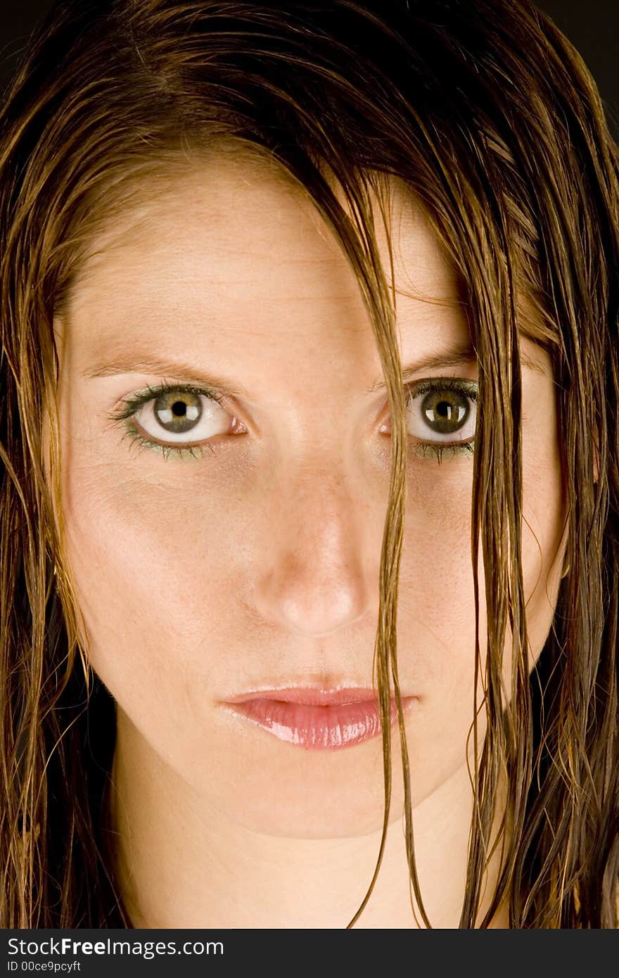 A young woman with wet hair against a plain background.