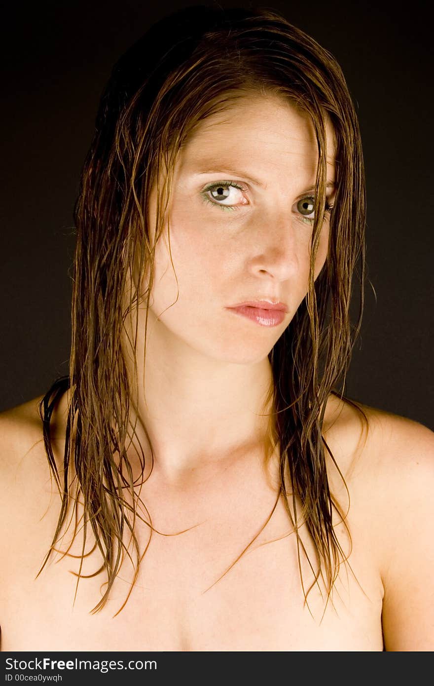 A young woman with wet hair against a plain background.