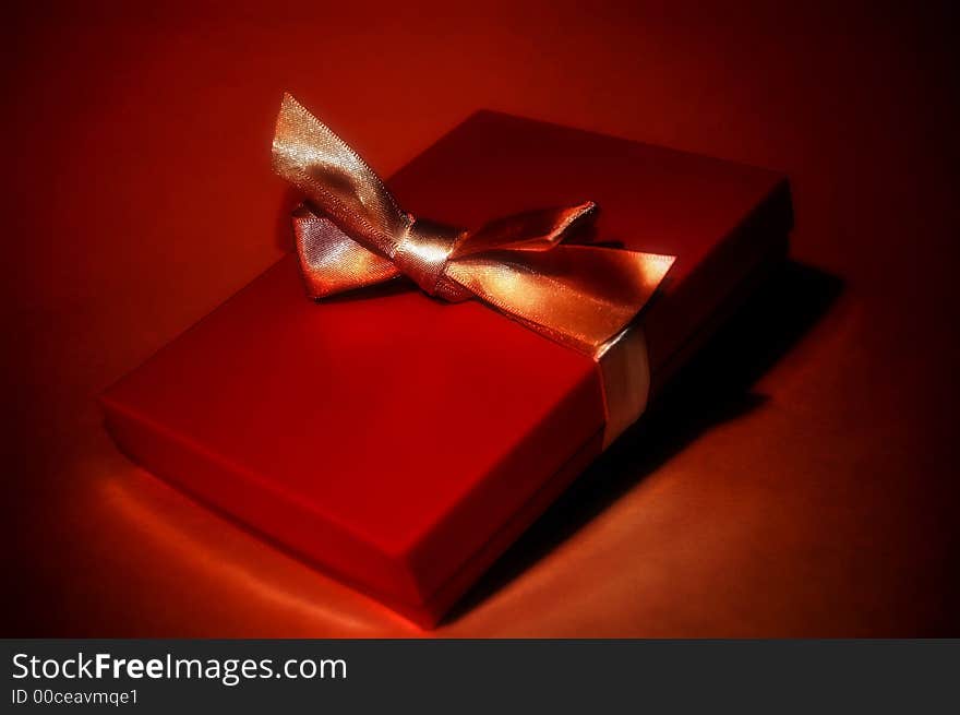 A red gift box with a golden ribbon. A red gift box with a golden ribbon.