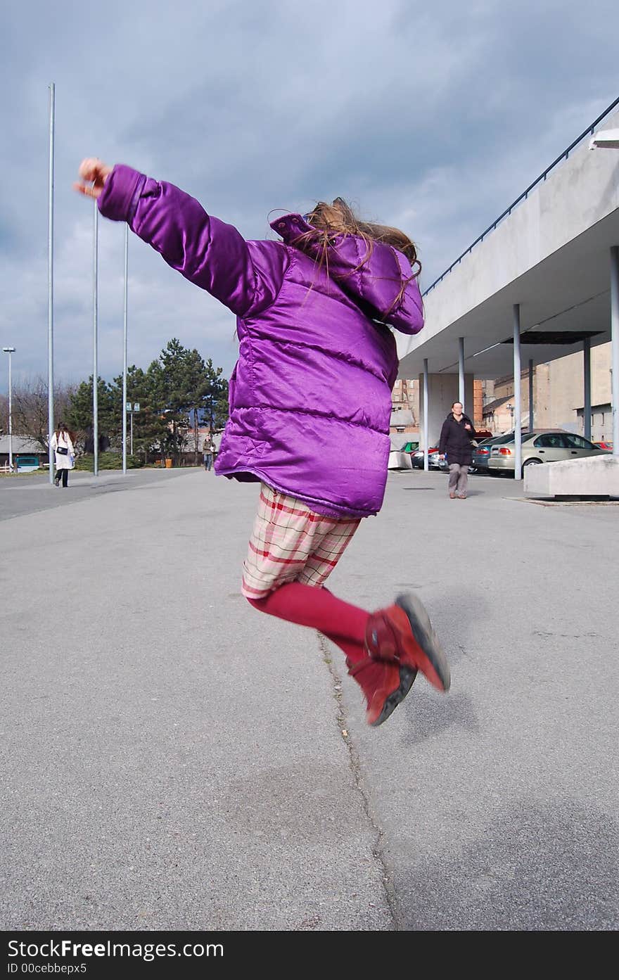 Little girl jumping happily in the city. Zagreb, Croatia.