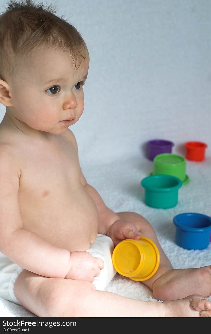 Image of adorable baby playing with stacking cups. Image of adorable baby playing with stacking cups