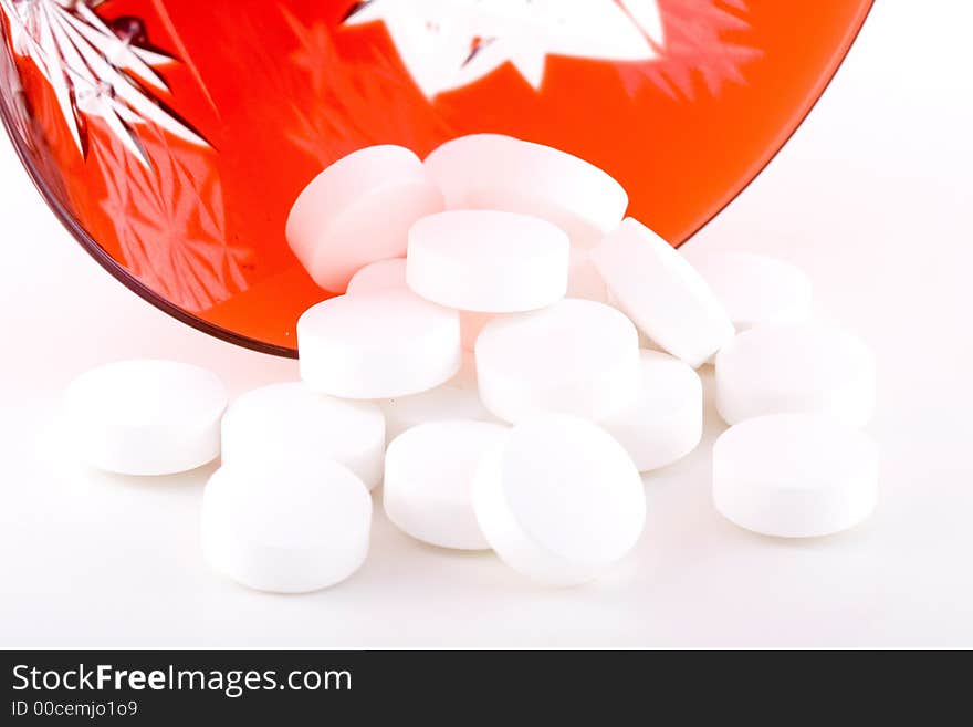 Shoot of pills and a red glass on a white background. Shoot of pills and a red glass on a white background.