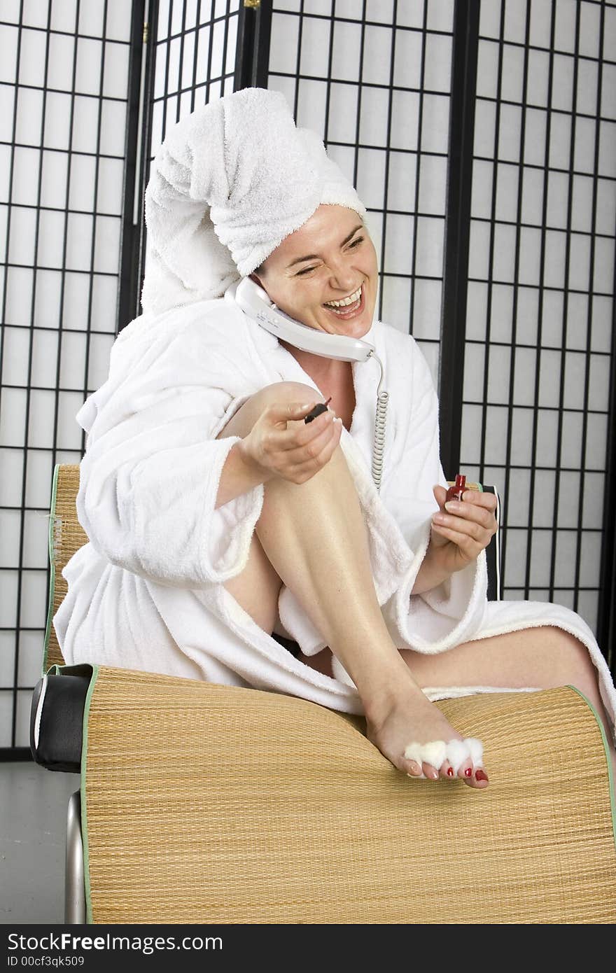 Woman happily chatting while painting her nails