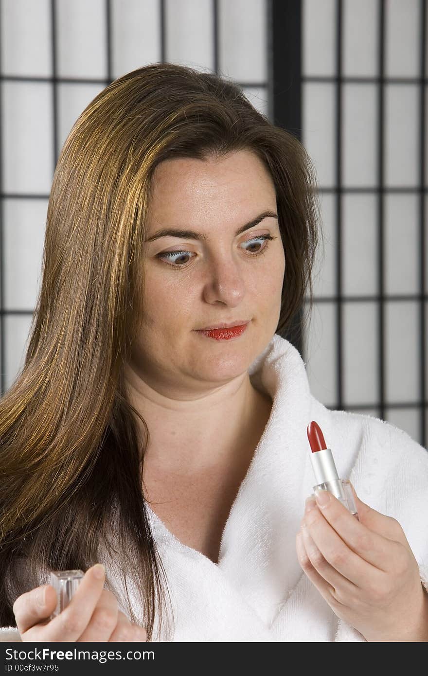 Woman puting on bright red lip stick. Woman puting on bright red lip stick