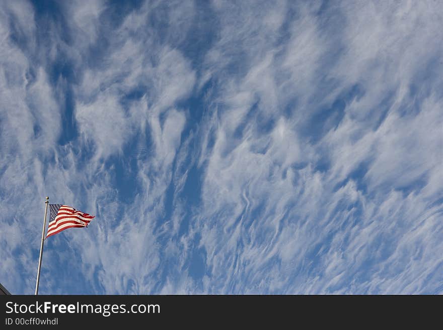 A torn american flag flies beneath dramatic winter clouds. (those were the clouds - this image has not been manipulated). A torn american flag flies beneath dramatic winter clouds. (those were the clouds - this image has not been manipulated)