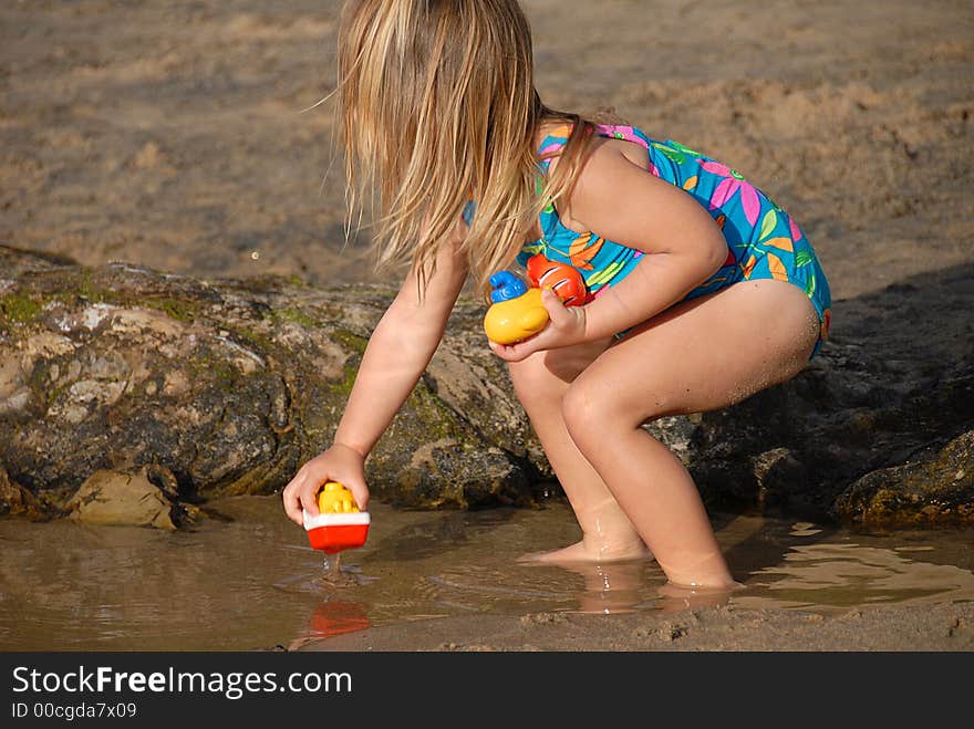 A girl is playing with toys on a beach