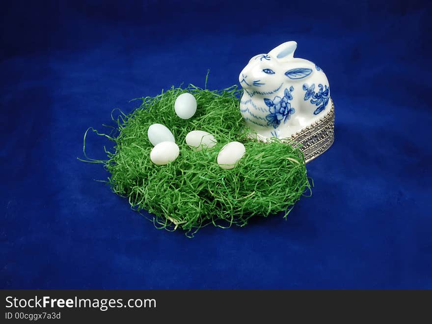 Porcelain delft Easter bunny watching over the Eastern egg nesting as the holiday season approaches. Porcelain delft Easter bunny watching over the Eastern egg nesting as the holiday season approaches