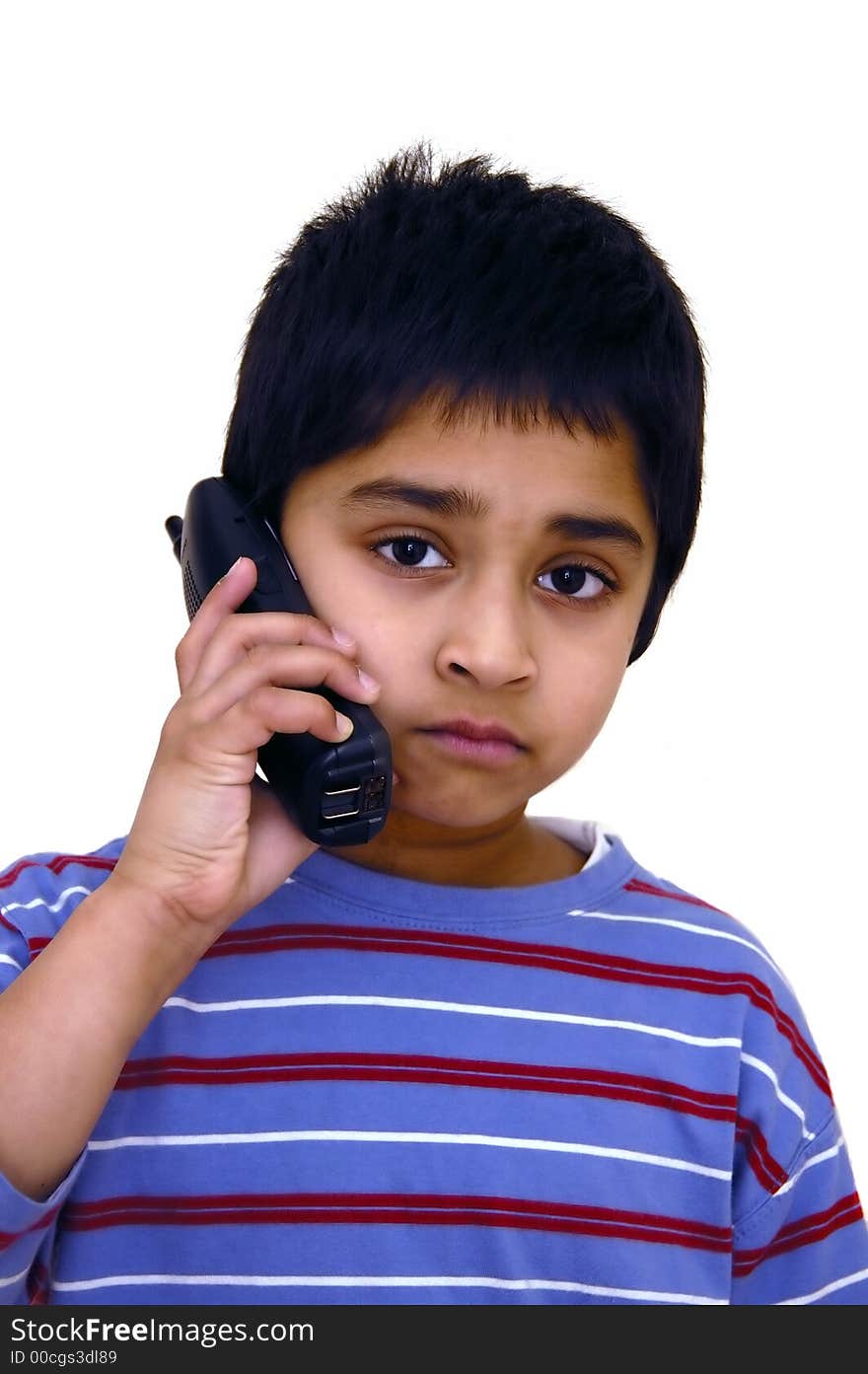 A kid speaking to some one over the phone. A kid speaking to some one over the phone