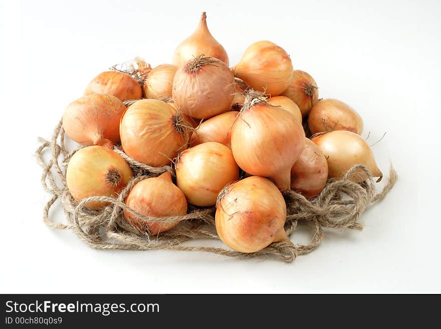 British baby onions on rope nest with white background