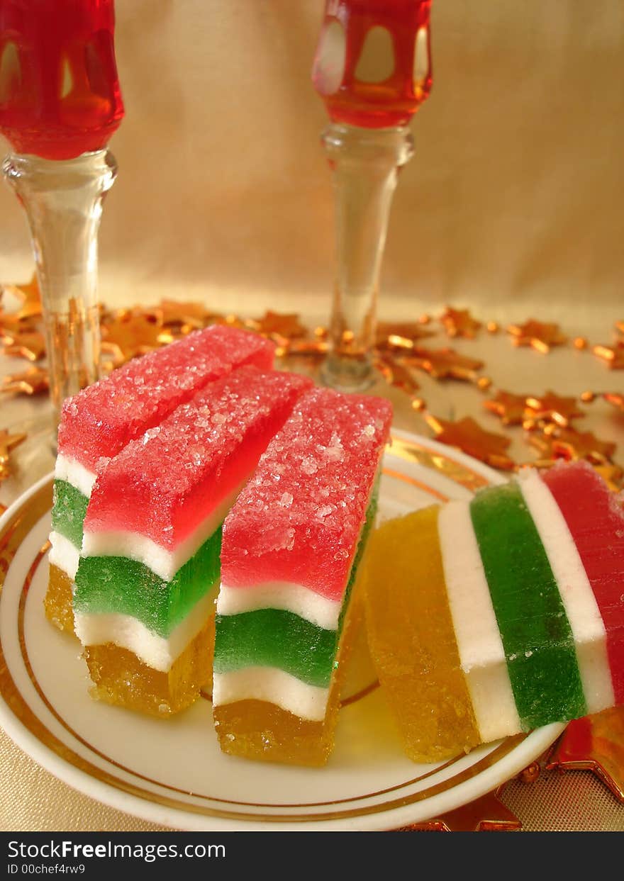 Celebratory table (Color Jelly cake on plate and two red glasses)