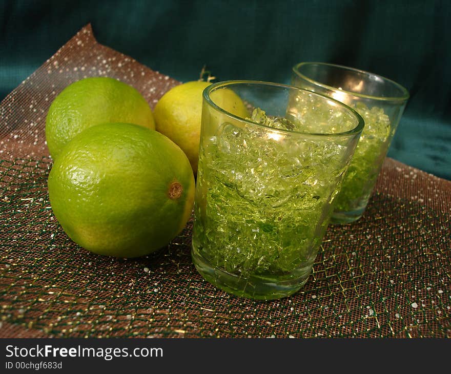 Green limes with candles on background