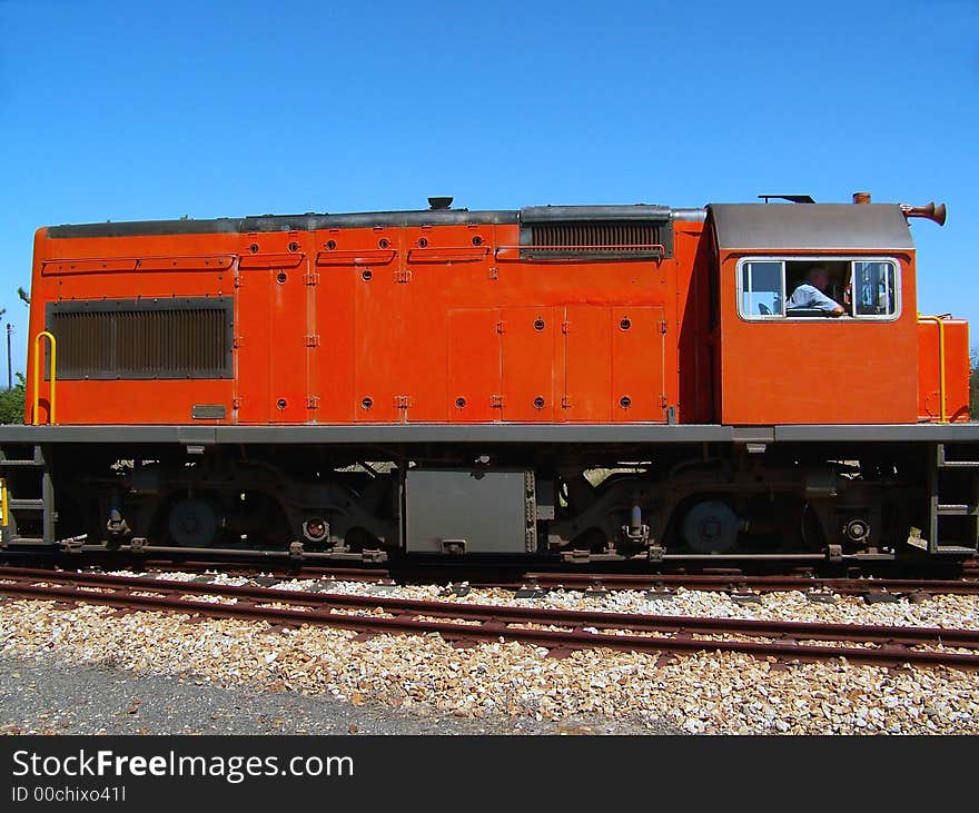 Bright orange train transporting it's passengers. Bright orange train transporting it's passengers