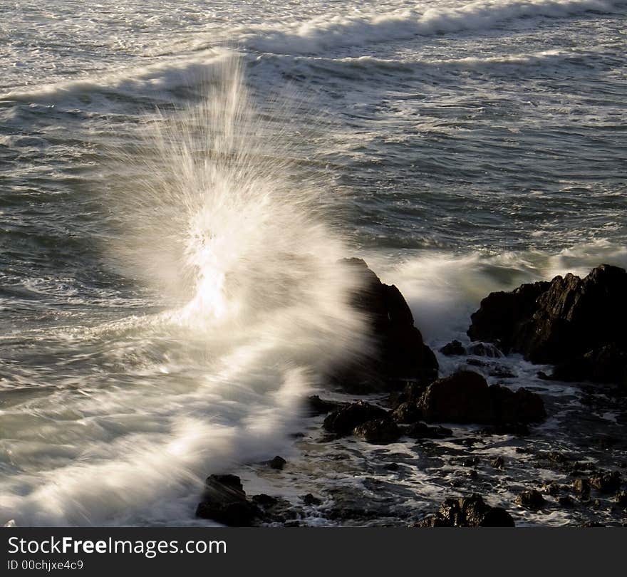 Large wave hitting rock with spray. Large wave hitting rock with spray