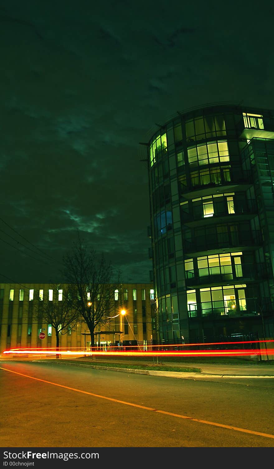 Condo complex at night with random blue window and steak of car lights. Condo complex at night with random blue window and steak of car lights