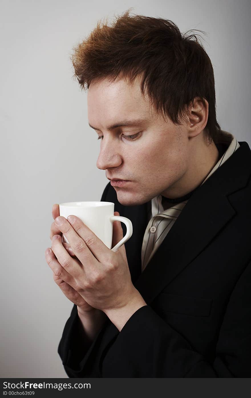 Businessman warming up with coffee cup after a cold day. Businessman warming up with coffee cup after a cold day