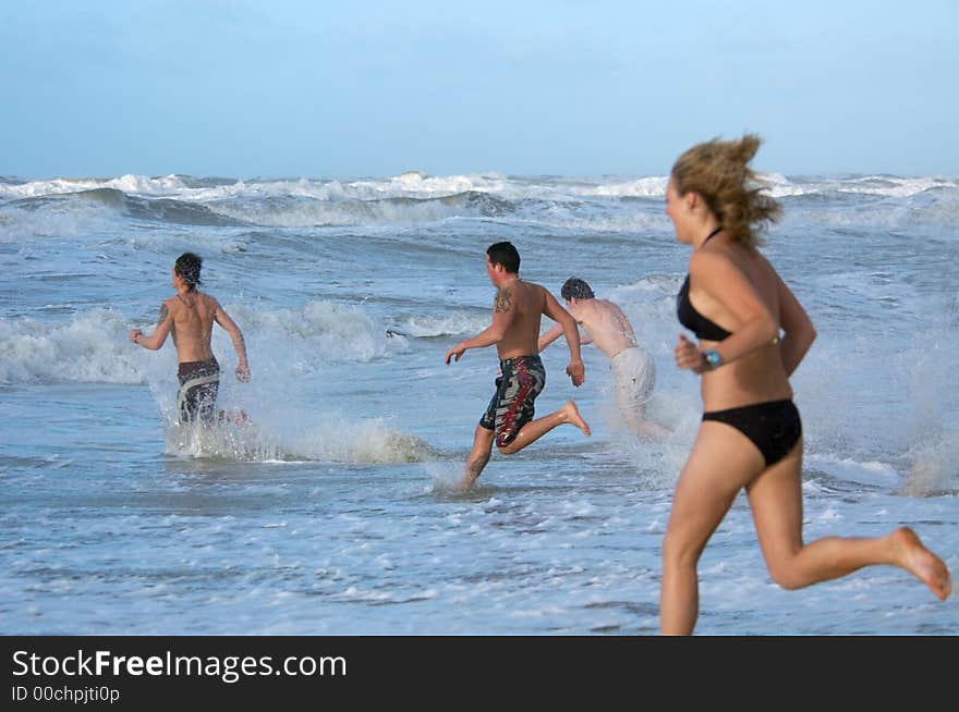 People running into the ocean. People running into the ocean