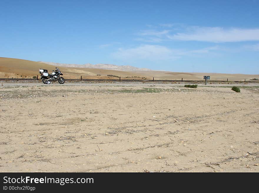 Motorbike against sand and sky