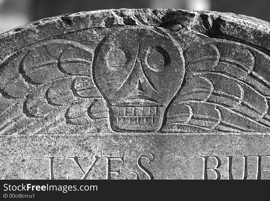 Detail of old head stone showing skull with wings. Detail of old head stone showing skull with wings