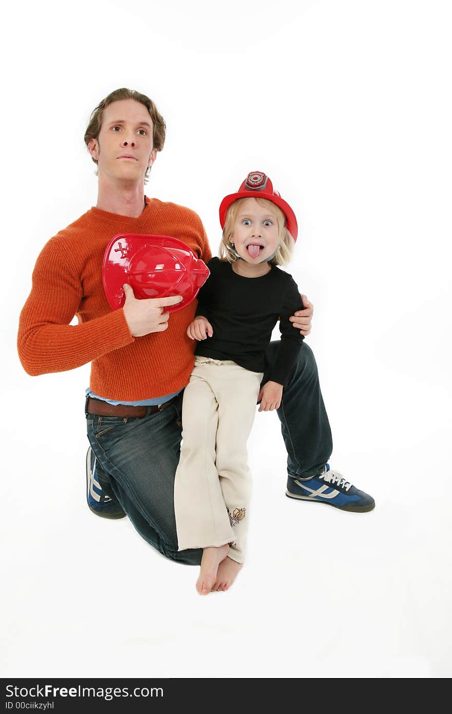 Adorable five year old with Dad wearing fire fighter hats. Adorable five year old with Dad wearing fire fighter hats