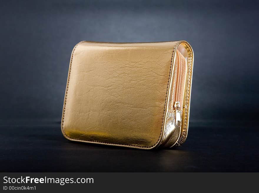 Gold purse in black background.