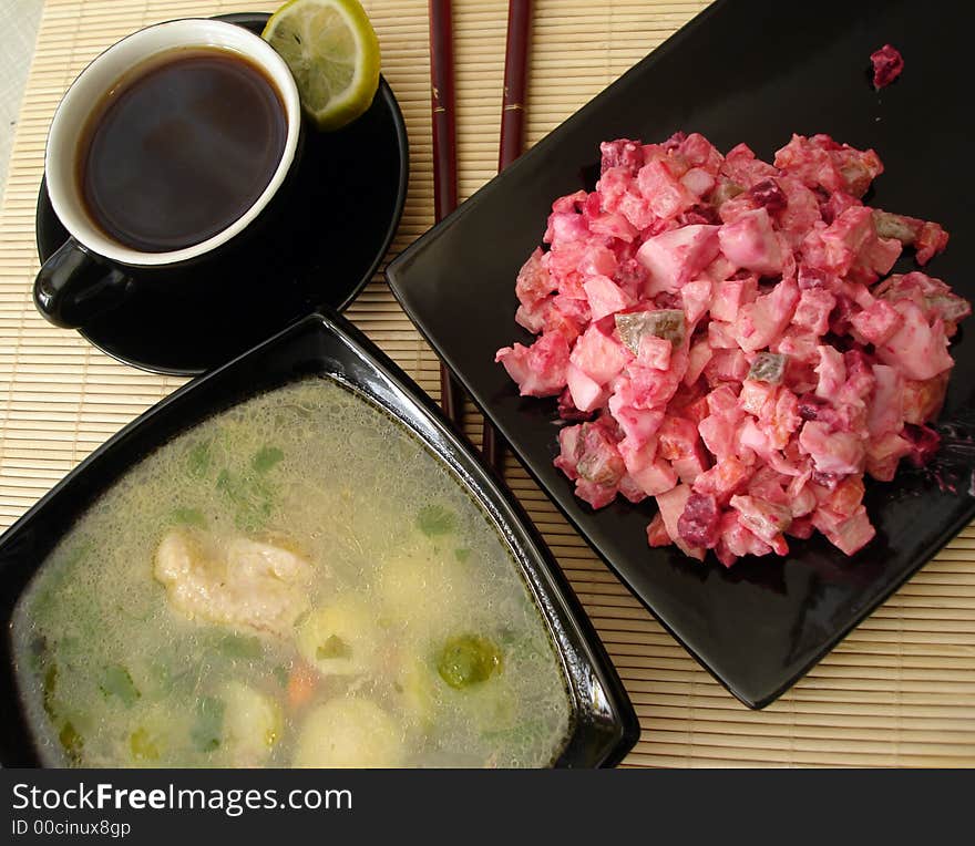 Green soup, red salad and cup of coffee served