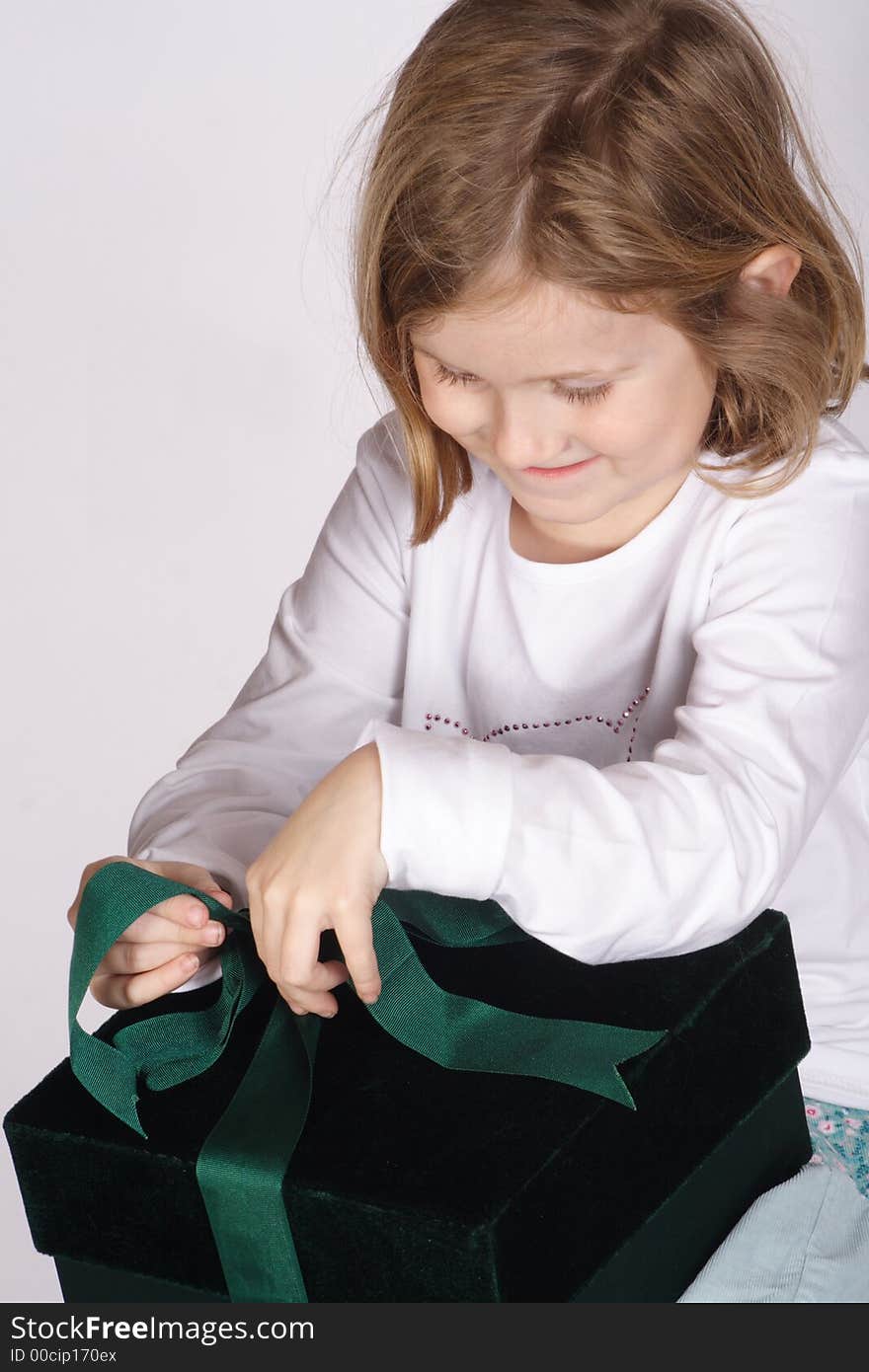 A young girl opening up a birthday present. A young girl opening up a birthday present