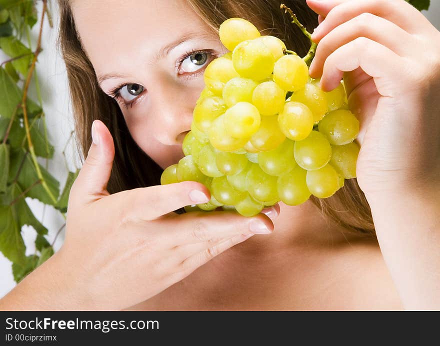 Beautiful young woman portrait with green grape