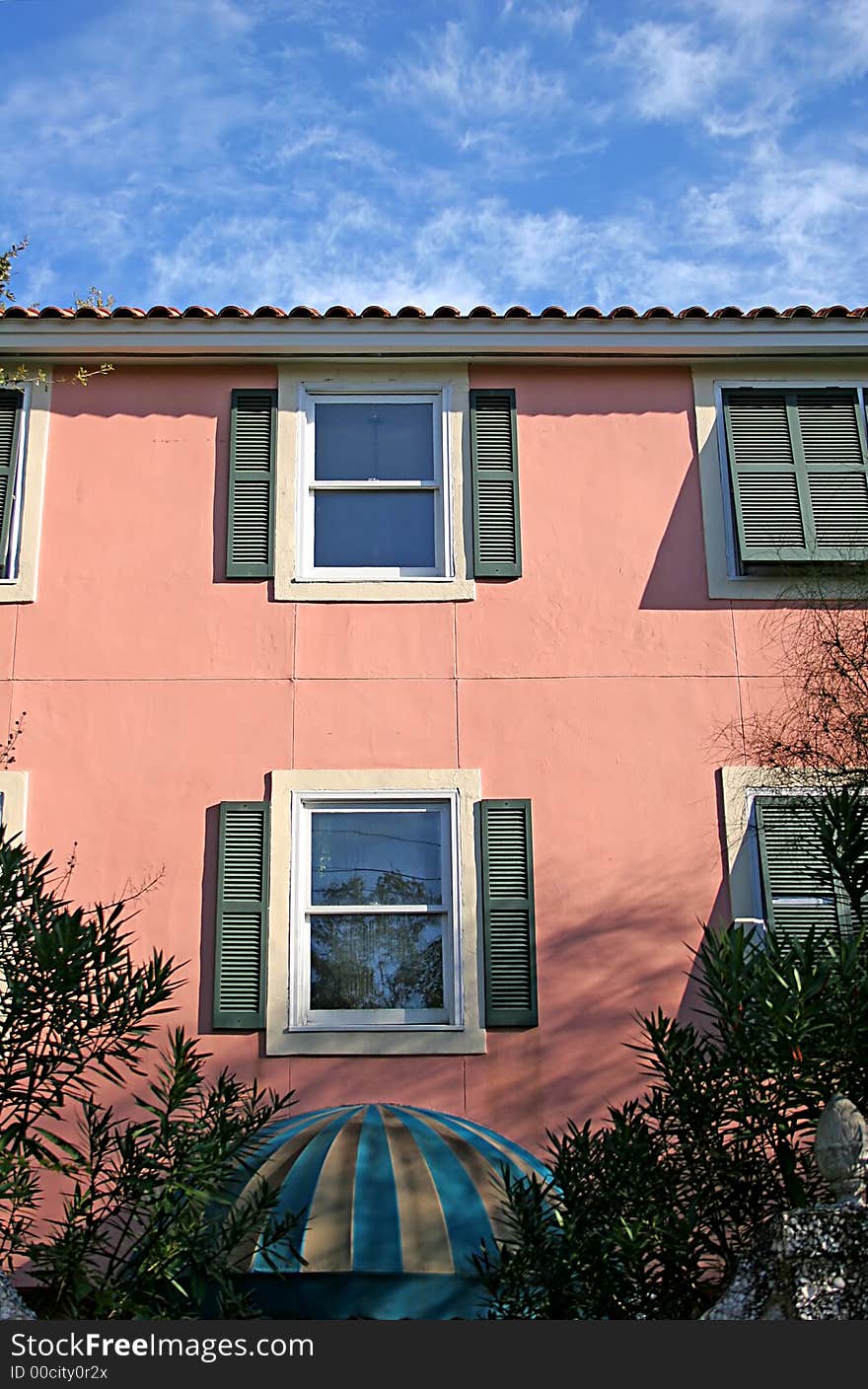 A Pink stucco coastal condo building and sky