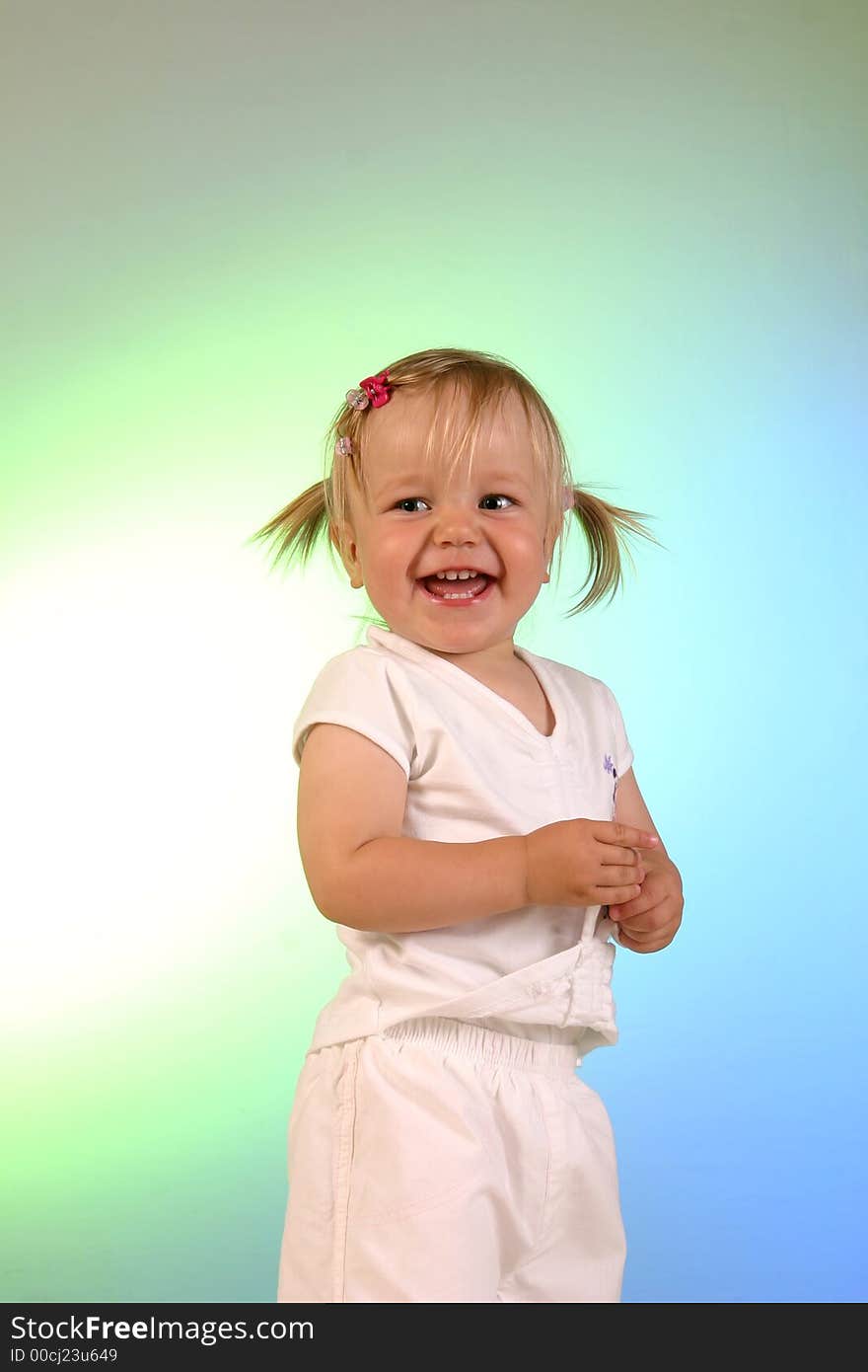 A studio shot of 2 years old little girl dressed white. Background colored by lights. A studio shot of 2 years old little girl dressed white. Background colored by lights