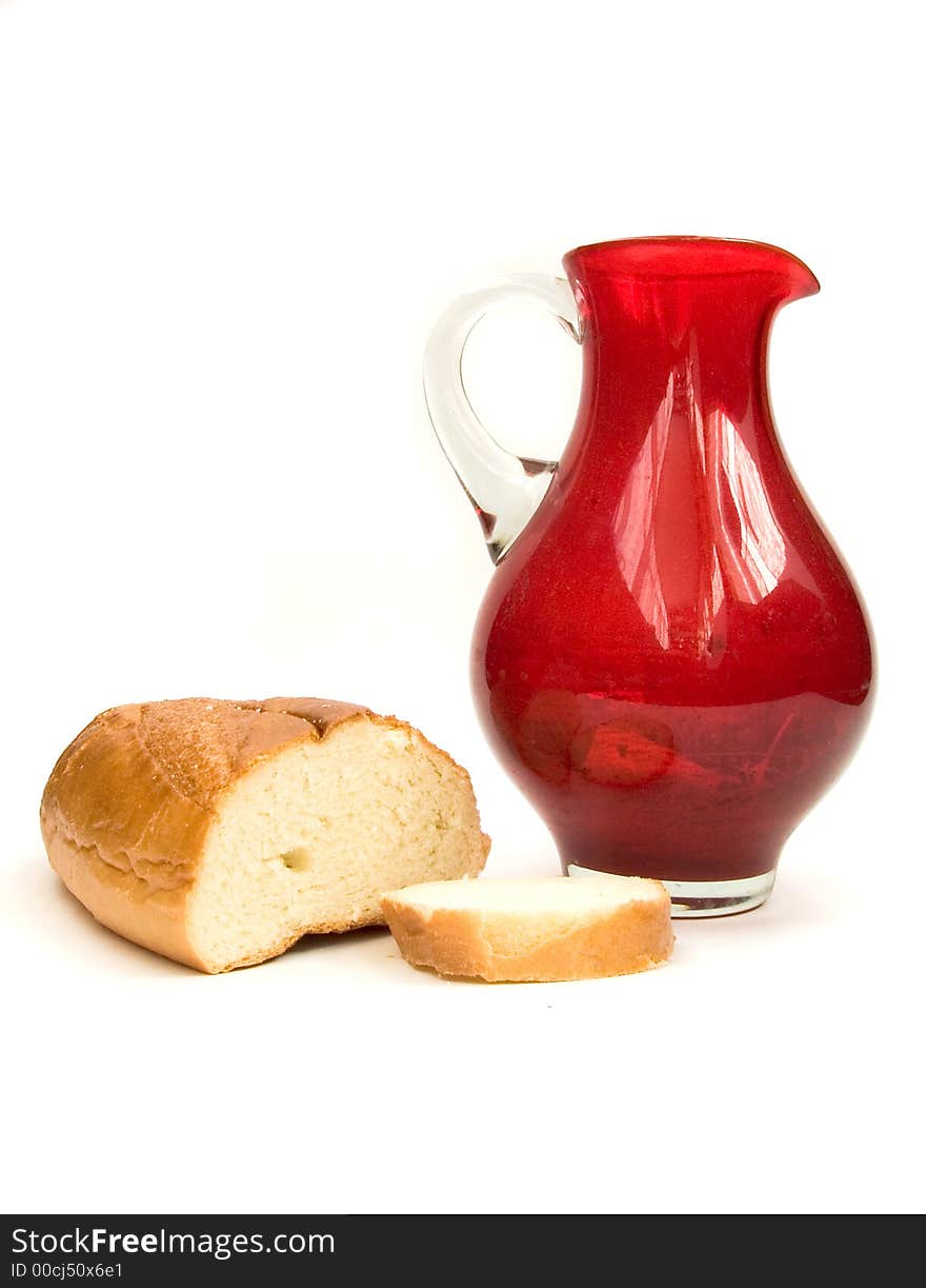 Bread and red jug on white. Bread and red jug on white