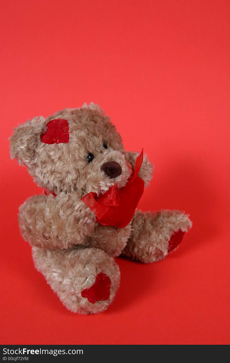 Brown Teddy Bear with hearts on red background. Brown Teddy Bear with hearts on red background