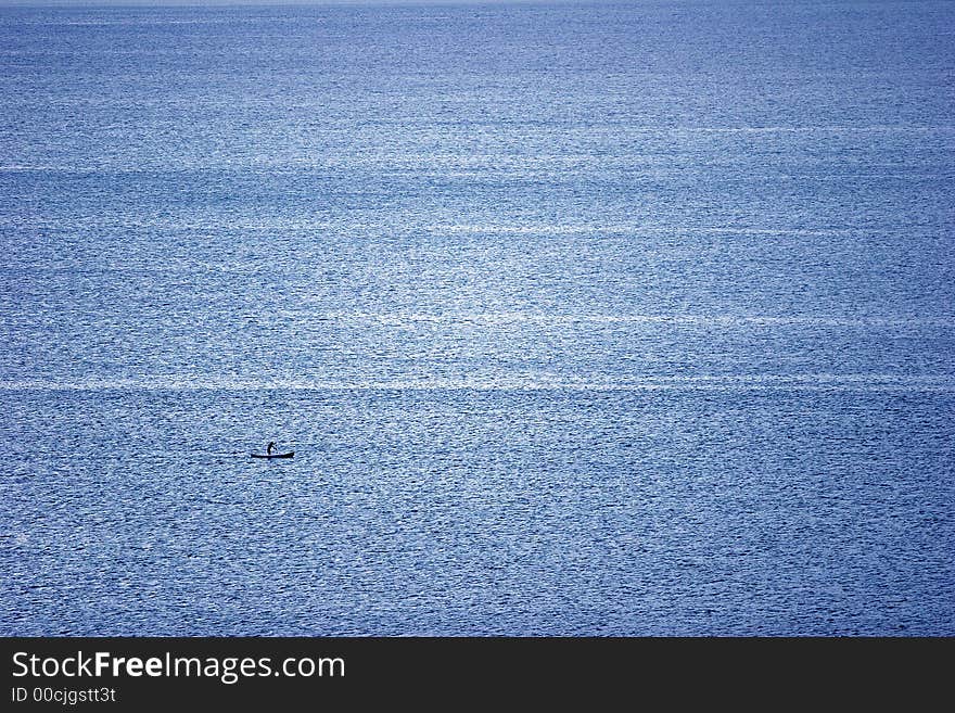 Blue ocean and one canoe in the right side in the corner. Blue ocean and one canoe in the right side in the corner