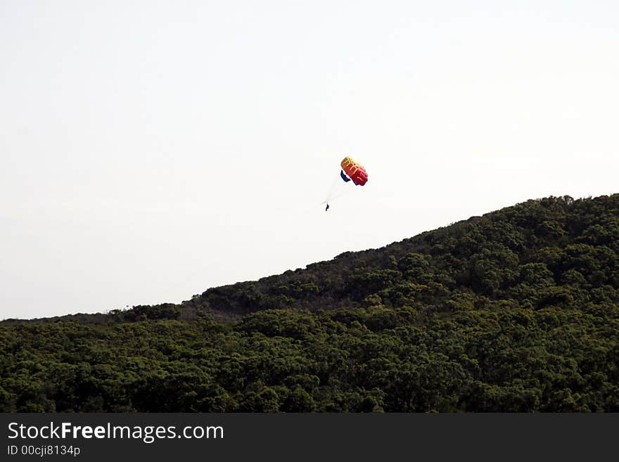 Colourful Parachute, Parasailing, Paragliding, Outdoor Sport Over A Hill With Green Trees