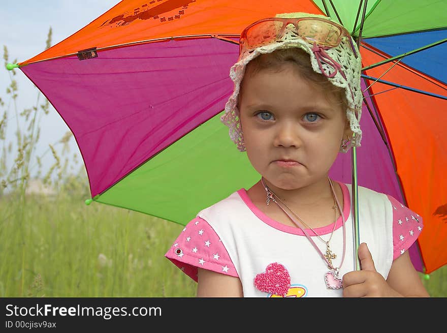 Pretty smiling child with umbrella and white hat