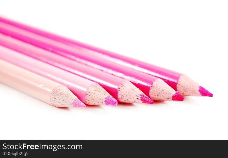 Row of spectrum of pink color pencils on a white background