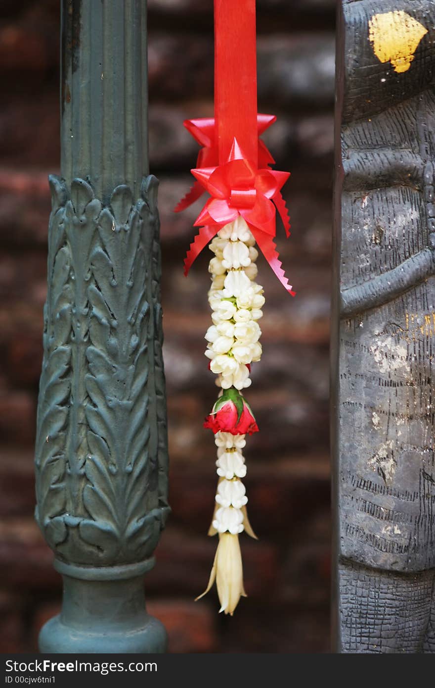 Flowers and ribbon hanging on a temple alter in Thailand