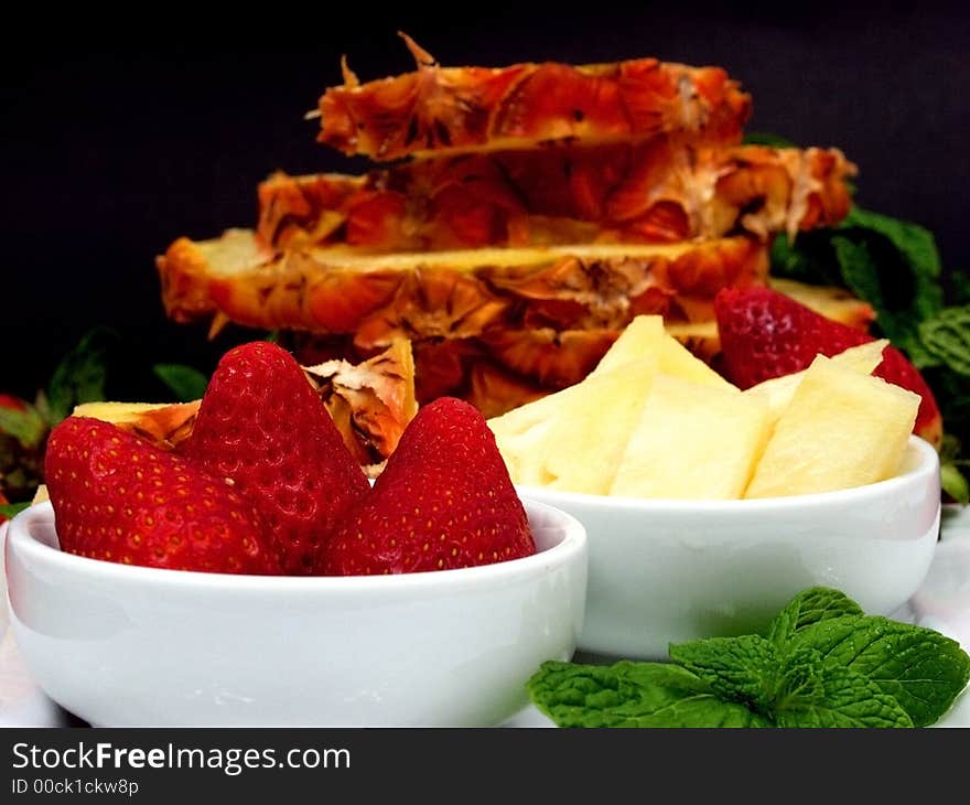 Fruit plate with strawberries and pineapple on black background. Fruit plate with strawberries and pineapple on black background