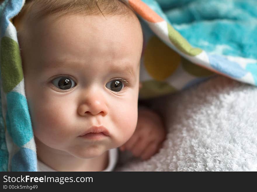 Image of baby peeking out from under a blanket. Image of baby peeking out from under a blanket